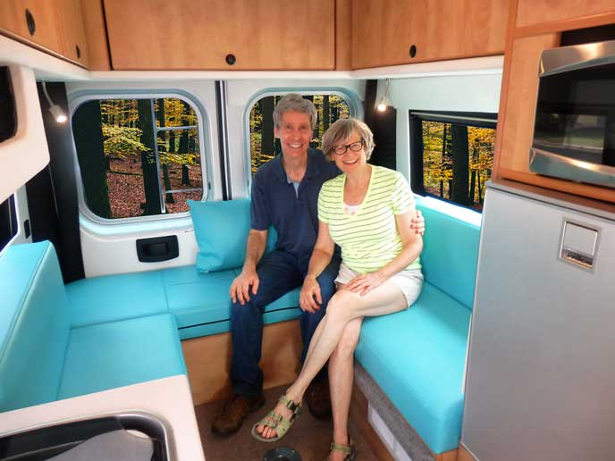 Sportsmobile owners, Gene and Shelly lounge in the back of their ProMaster conversion.
