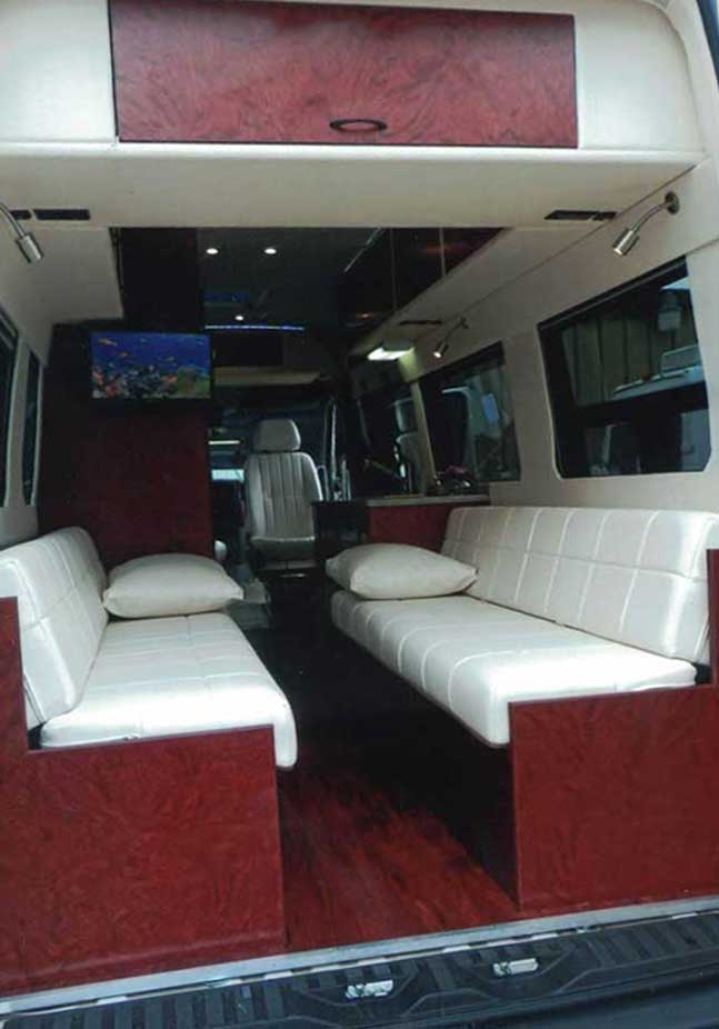 Inteior view of upgraded dinette that seats six in a custom Sportsmobile van conversion.